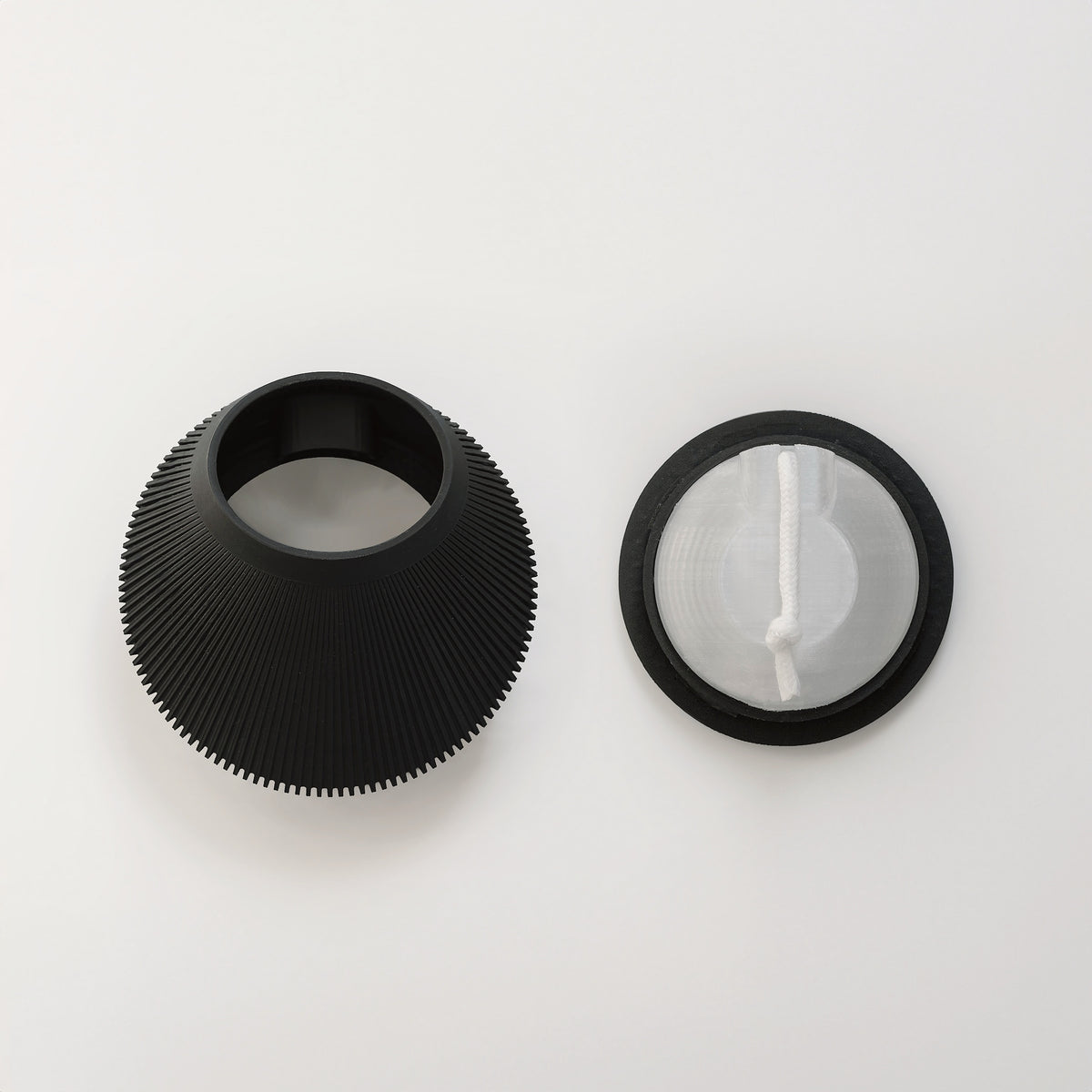Black VerdiPot Bevel wall planter beside its separate circular component with a self-watering wick.