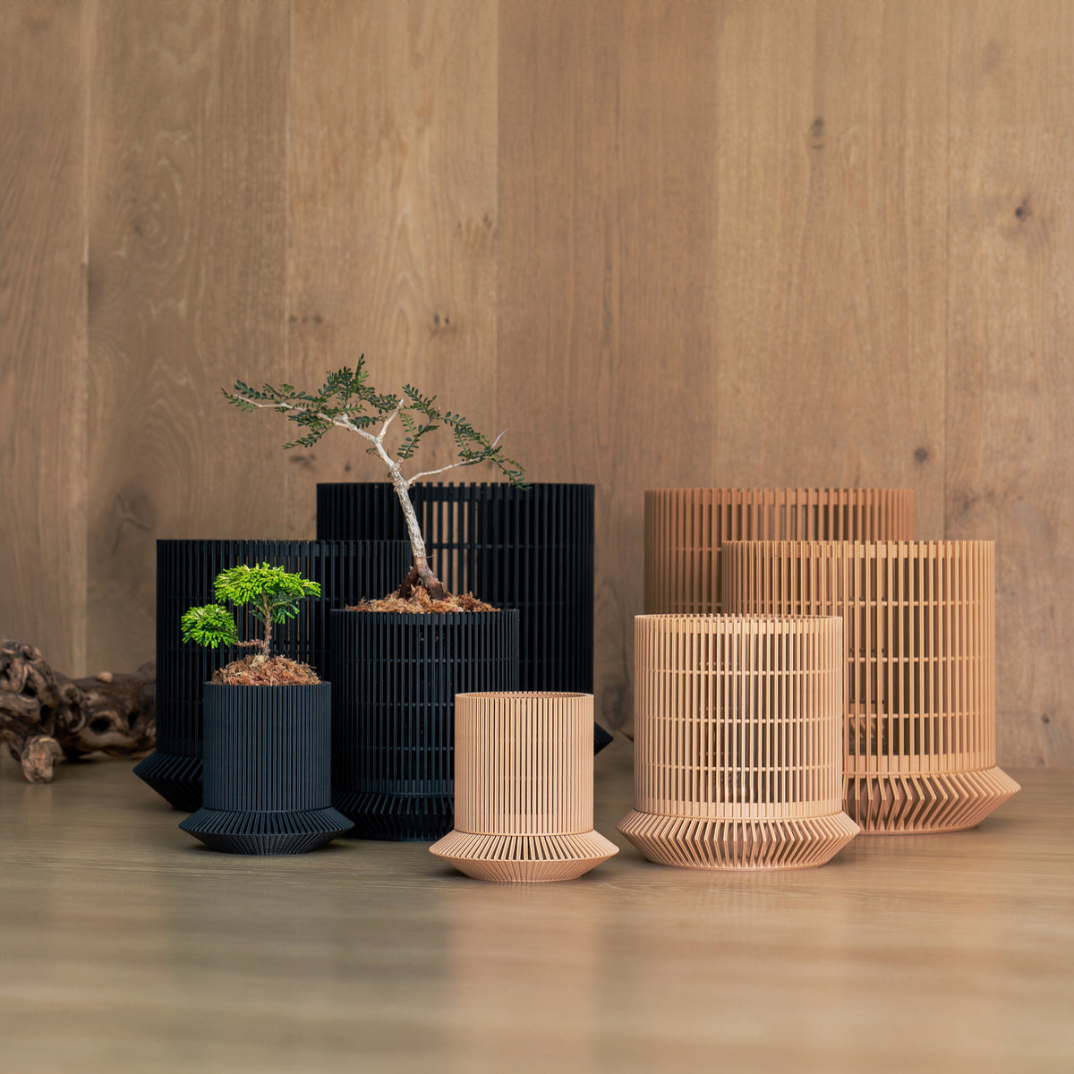 Black and brown VerdiPot Koshido self-watering and air-pruning planters in several sizes, some holding plants.