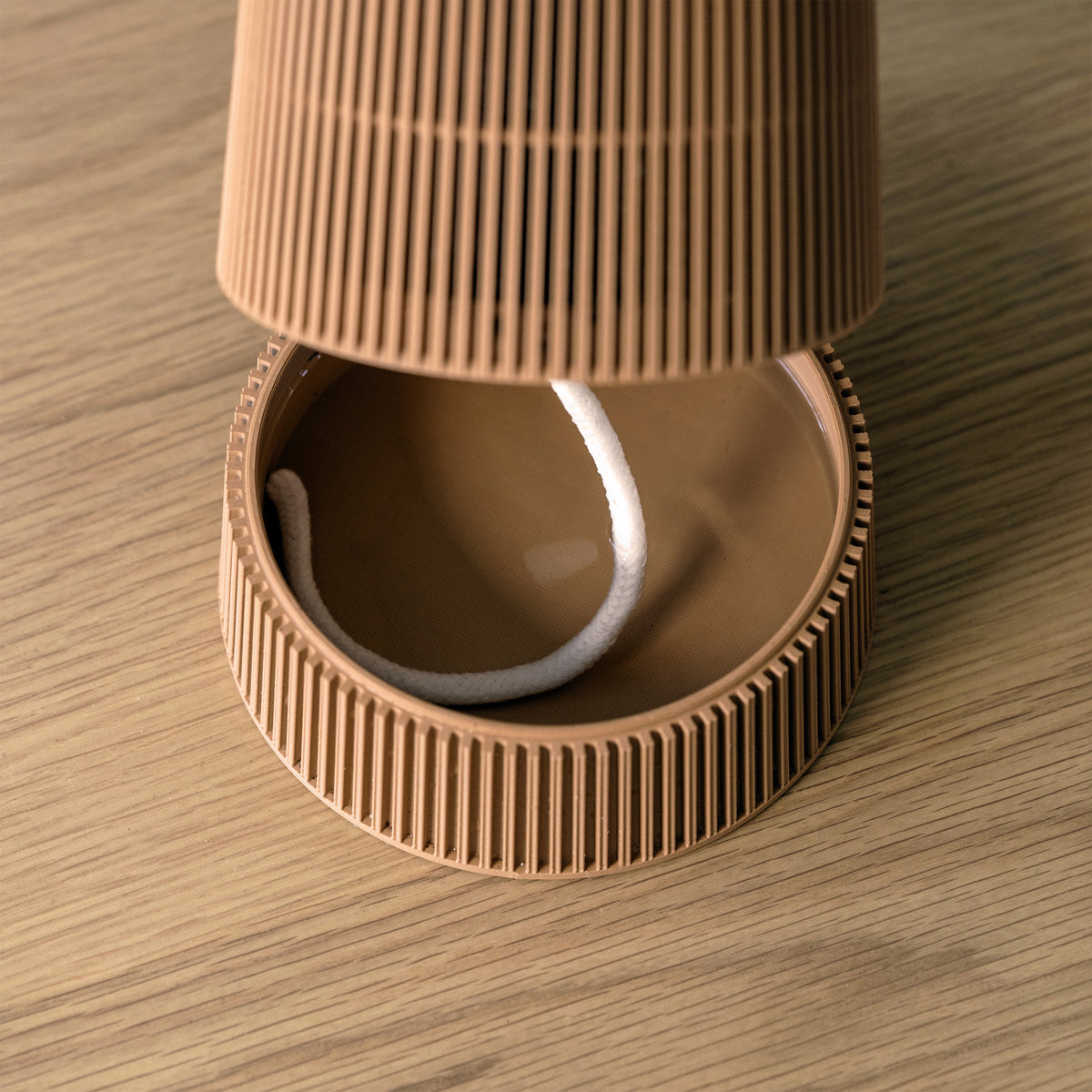 Brown VerdiPot lattice planter lifted above its reservoir, showing the self-watering wick.