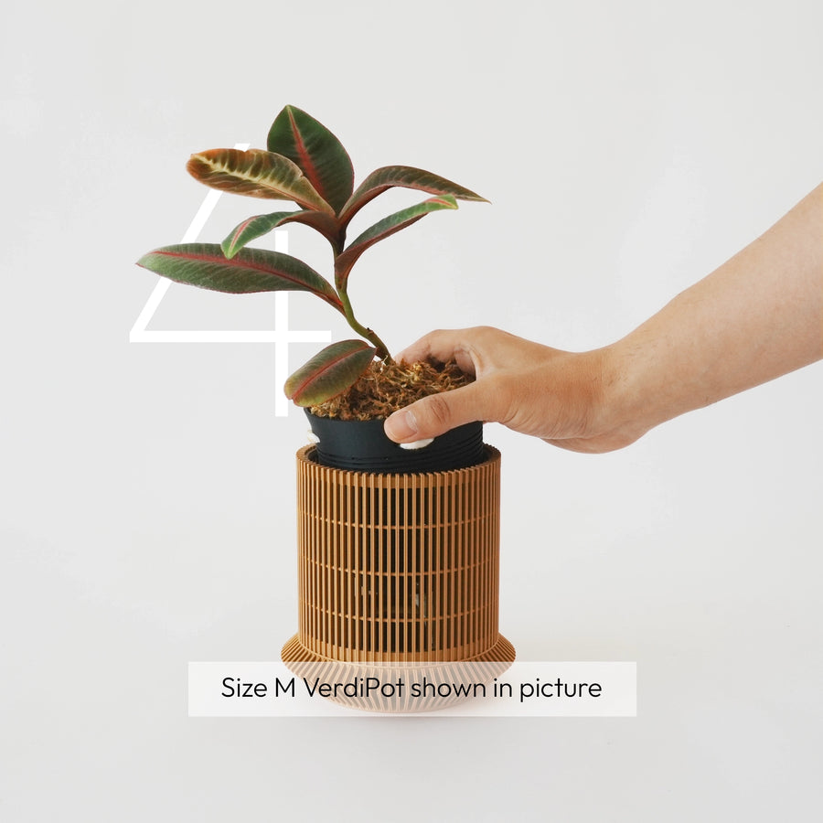 A planted inner pot being lowered into the Koshido exterior.